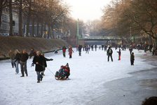 900010 Afbeelding van schaatsers (en sleeërs) op de bevroren Stadsbuitengracht te Utrecht, met op de achtergrond de ...